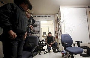 Ryan Bundy (L) and Wes Kjar, an occupier, take up positions after a door was rattled in an office at the Malheur National Wildlife Refuge near Burns, Oregon, January 6, 2016. REUTERS/Jim Urquhart