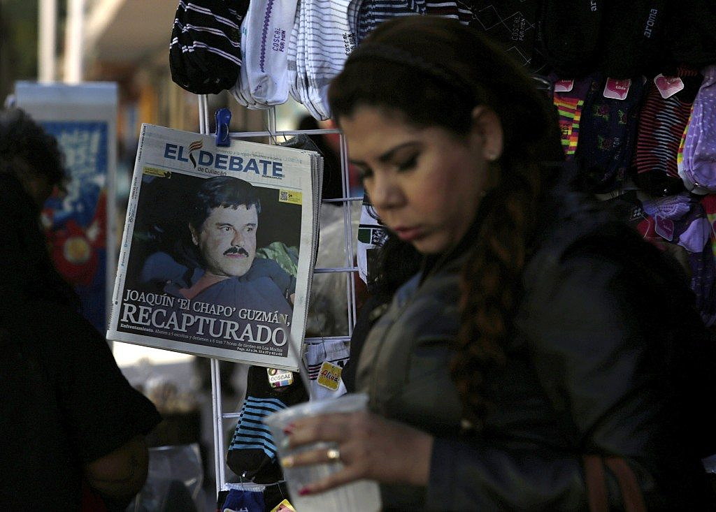 A woman walks past a newspaper showing a photograph of recaptured drug lord Joaquin &quot;Chapo&quot; Guzman on its front page in Culiacan, Mexico, January 9, 2016. REUTERS/Daniel Becerril