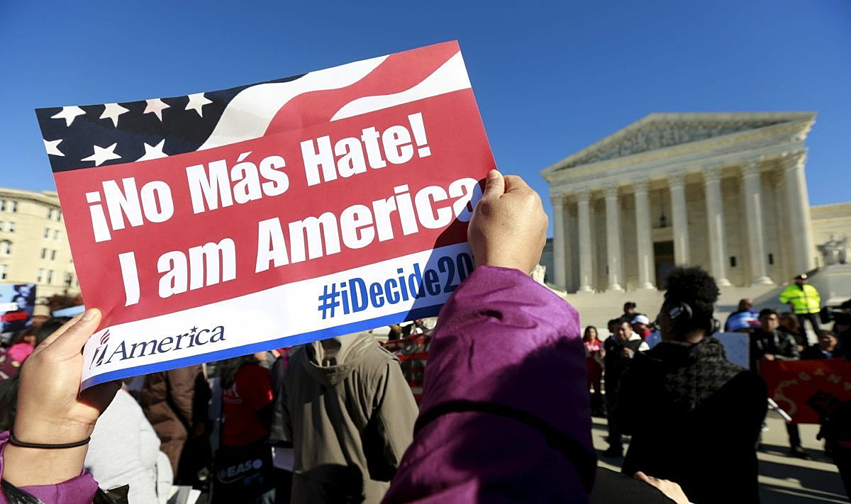 A protester holds a sign as immigrants and community leaders rally in front of the U.S. Supreme Court to mark the one-year anniversary of President Barack Obama's executive orders on immigration in Washington, in this file photo taken November 20, 2015. REUTERS/Kevin Lamarque/Files